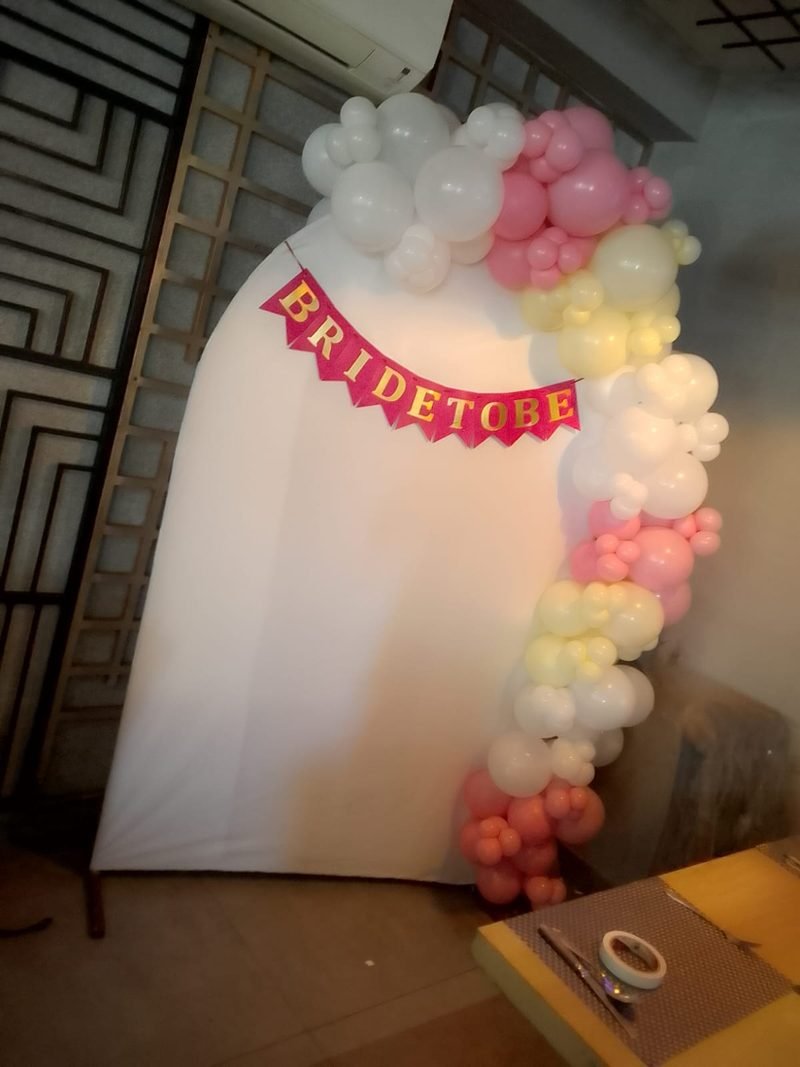 White arch backdrop with pink and cream balloons and a Bride To Be banner – Events In Sialkot