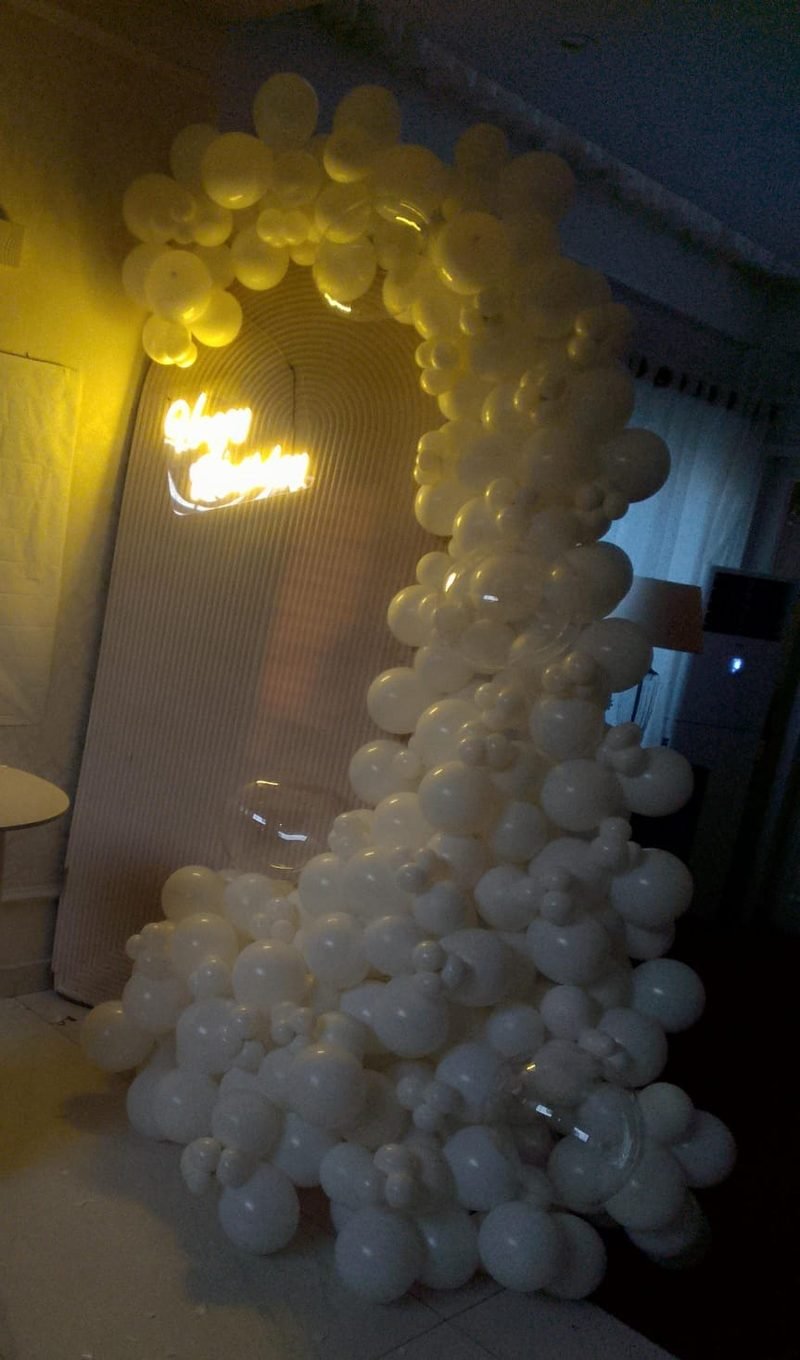 Large white balloon cloud beside a round-ridged backdrop with a glowing neon sign – Events In Sialkot