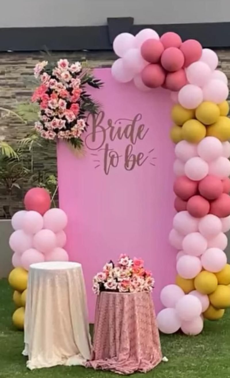 Bride to be setup with a pink board, balloon garland and flower arrangement – Events In Sialkot