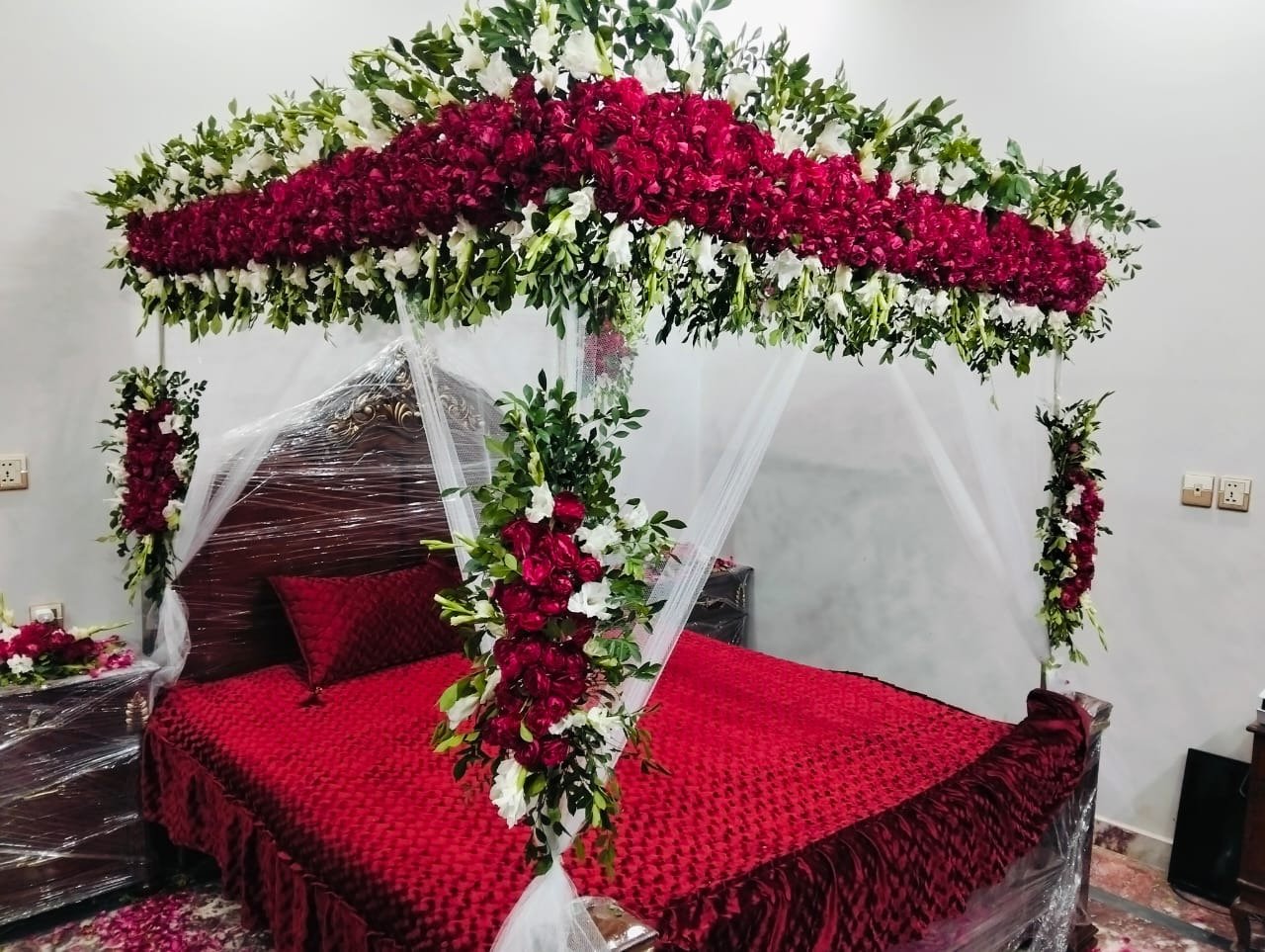 Bridal room bed canopy with red roses and white flowers in Sialkot – Events In Sialkot