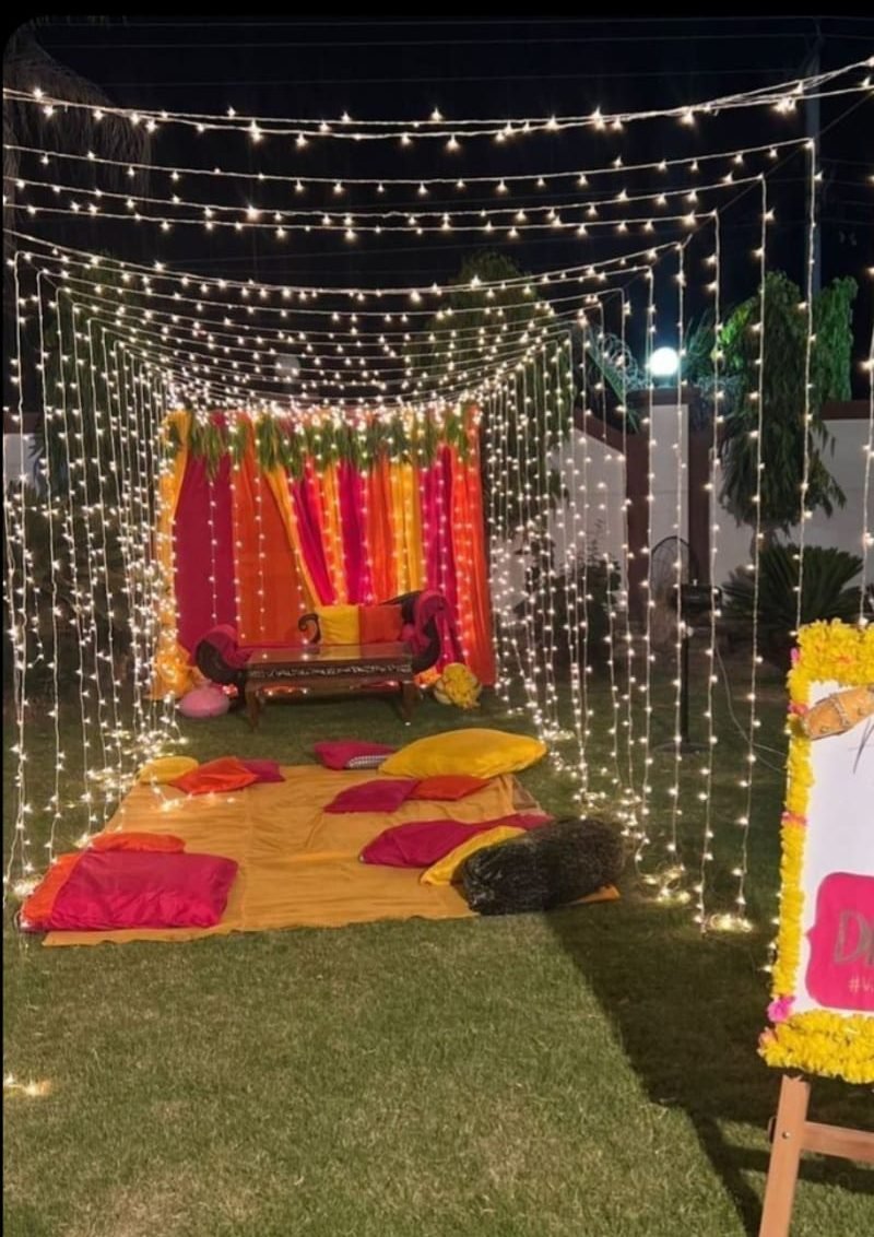 Garden mehndi setup with fairy-light curtains and colourful drapes – Events In Sialkot